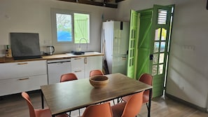 Una cocina compacta con comedor, una puerta verde y vistas al exterior.