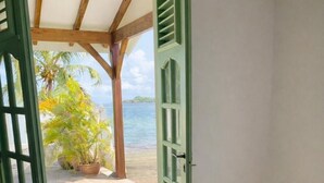 Une chambre avec un lit, une porte verte et une vue sur la plage.