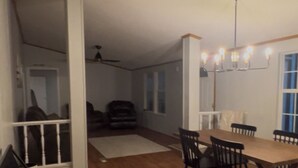 A dining area with a wooden table and chairs, a black bench, and a ceiling fan. - Lakefront Home-Beautiful Views & Private Dock 15-20 to Clemson, Anderson,Seneca (Townville)