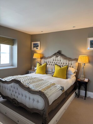 A bedroom with a large bed, two bedside lamps, a window with a view, and a framed picture on the wall. - Luxury Town House - Newquay 5 Mins to Beach (Newquay)