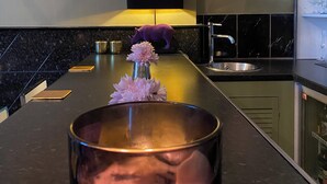 A kitchen with a marble countertop, a sink, a purple pig figurine, and a framed artwork above the counter. - Luxury Town House - Newquay 5 Mins to Beach (Newquay)