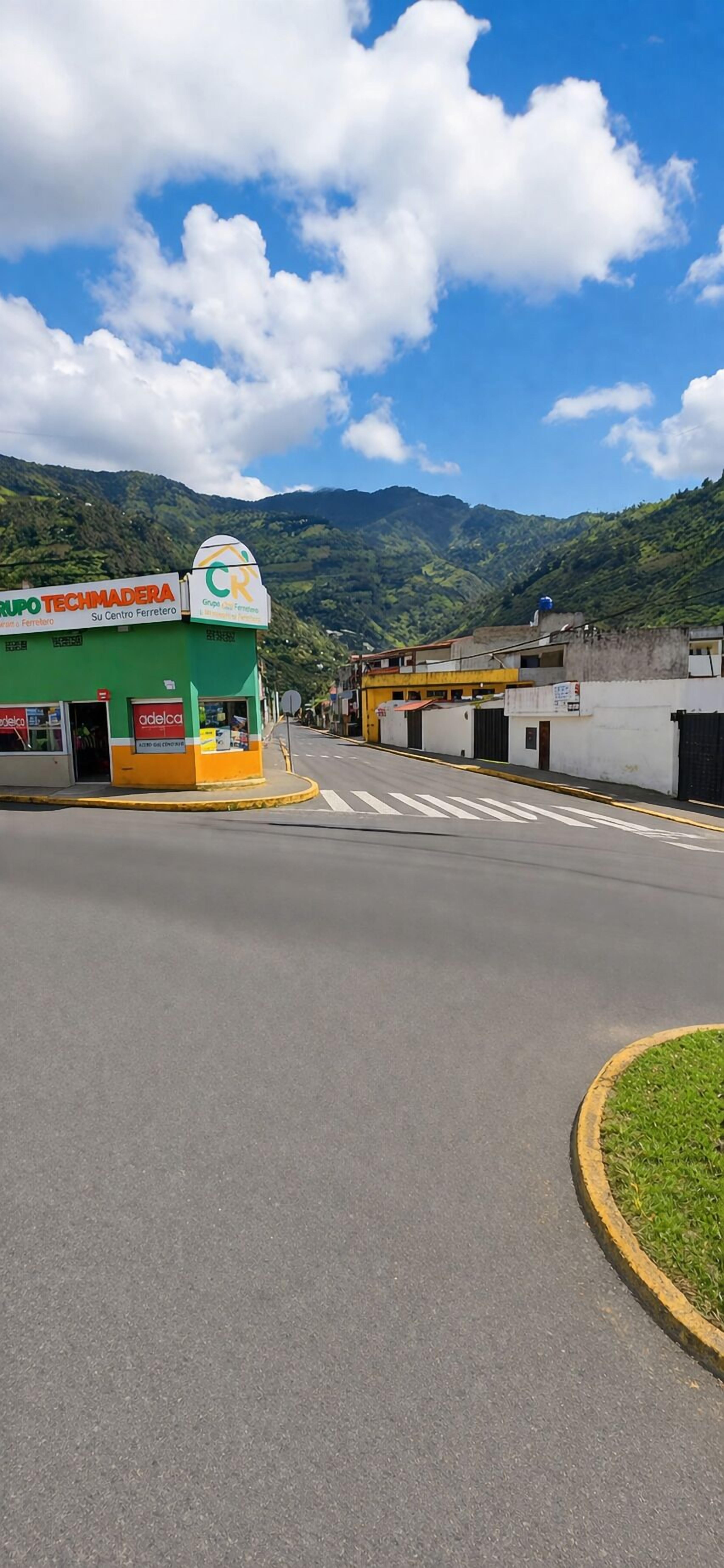 A street with a green building labeled 'Grupo Techimadera' and a sign for 'Adelca.'
