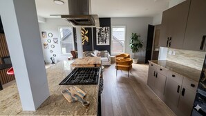 Une cuisine moderne dotée d’un îlot central, d’une cuisinière intégrée et d’une grande fenêtre.