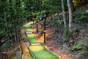 A forested area with a series of green, grass-like pathways. - Luxury Tepee | Near Dollywood|Resort Access|Pool (Sevierville)