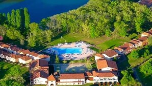 An aerial view of a resort with a swimming pool surrounded by villas. - Appartement du Lac (Monflanquin)