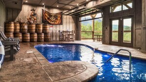 Un espace piscine agrémenté de barils en bois, d’une statue tiki et offrant une vue sur l’extérieur.