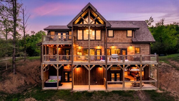 Une maison en bois à deux étages, dotée de nombreux balcons et d’une grande véranda.