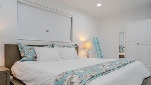 Une chambre à coucher avec un lit, une table de chevet, une lampe, une armoire et une fenêtre.