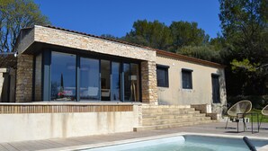 A modern house with a swimming pool, stone facade, large windows, and outdoor furniture. - Small house near Uzes and the Pont du Gard, ideal for 2 or 4 people (Saint-Maximin)