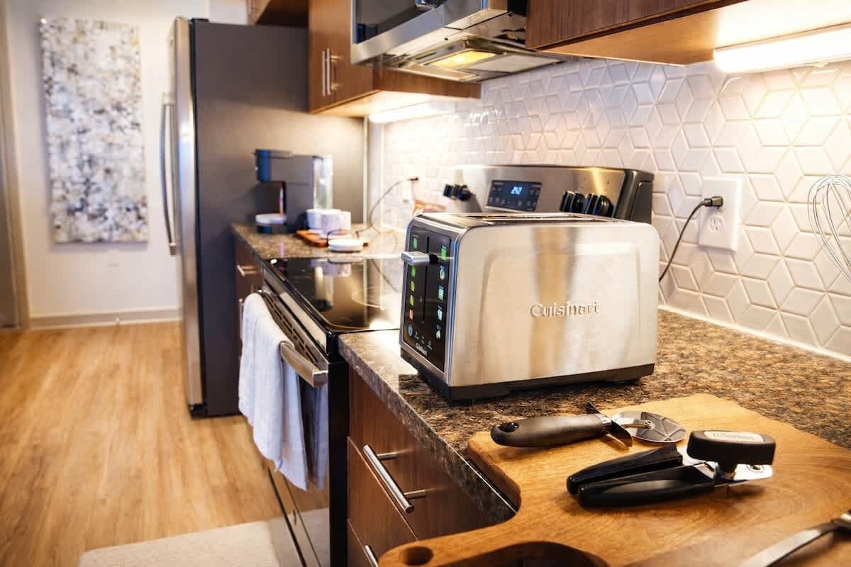 A modern kitchen with a stainless steel toaster, a microwave, and a kettle.