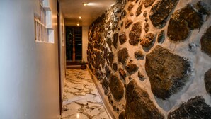 Ein Korridor mit Marmorboden und Steinwand.