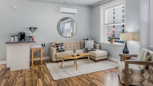 A living room with a sofa, coffee table, and a window with blinds.