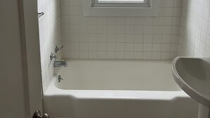 A bathroom with a bathtub, a window, and a sink. - Cozy 2-bedroom house in fantastic Point Pleasant with AC (Point Pleasant)
