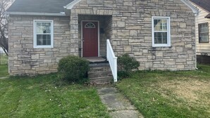 A stone house with a red door, white windows, and a small front porch. - Cozy 2-bedroom house in fantastic Point Pleasant with AC (Point Pleasant)