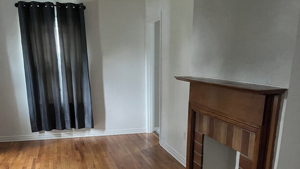A room with hardwood flooring, a fireplace, and a door. - Cozy 2-bedroom house in fantastic Point Pleasant with AC (Point Pleasant)
