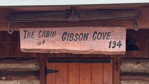 Una porta de fusta amb un cartell a la part superior que diu 'The Cabin at Gibson Cove 134'.