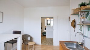 A kitchen with a wooden countertop, a sink, a chair, and a dining table. - Le Shannon - Porte de Bordeaux (Pessac)