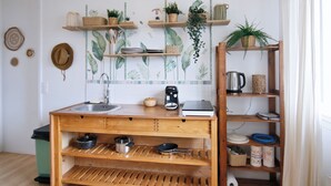 A kitchen with wooden shelves, a sink, and various kitchen utensils. - Le Shannon - Porte de Bordeaux (Pessac)