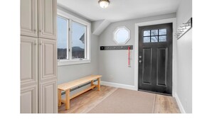 A room with a bench, a door, a coat rack, and a window. - Sunday River Group Getaway (Bethel)