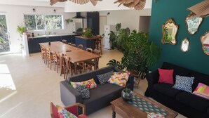 A spacious living area with a sofa, coffee table, and dining table. - Group holiday in the garrigue - 12 people - total peace and quiet (Saint-Martin-de-Londres)