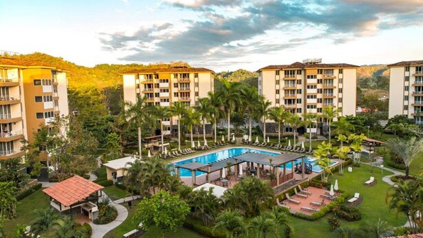 A hotel with multiple buildings, a central pool area, and surrounding greenery. - Family-friendly Condo With Pool View, Walk to Jaco Beach (Jacó)
