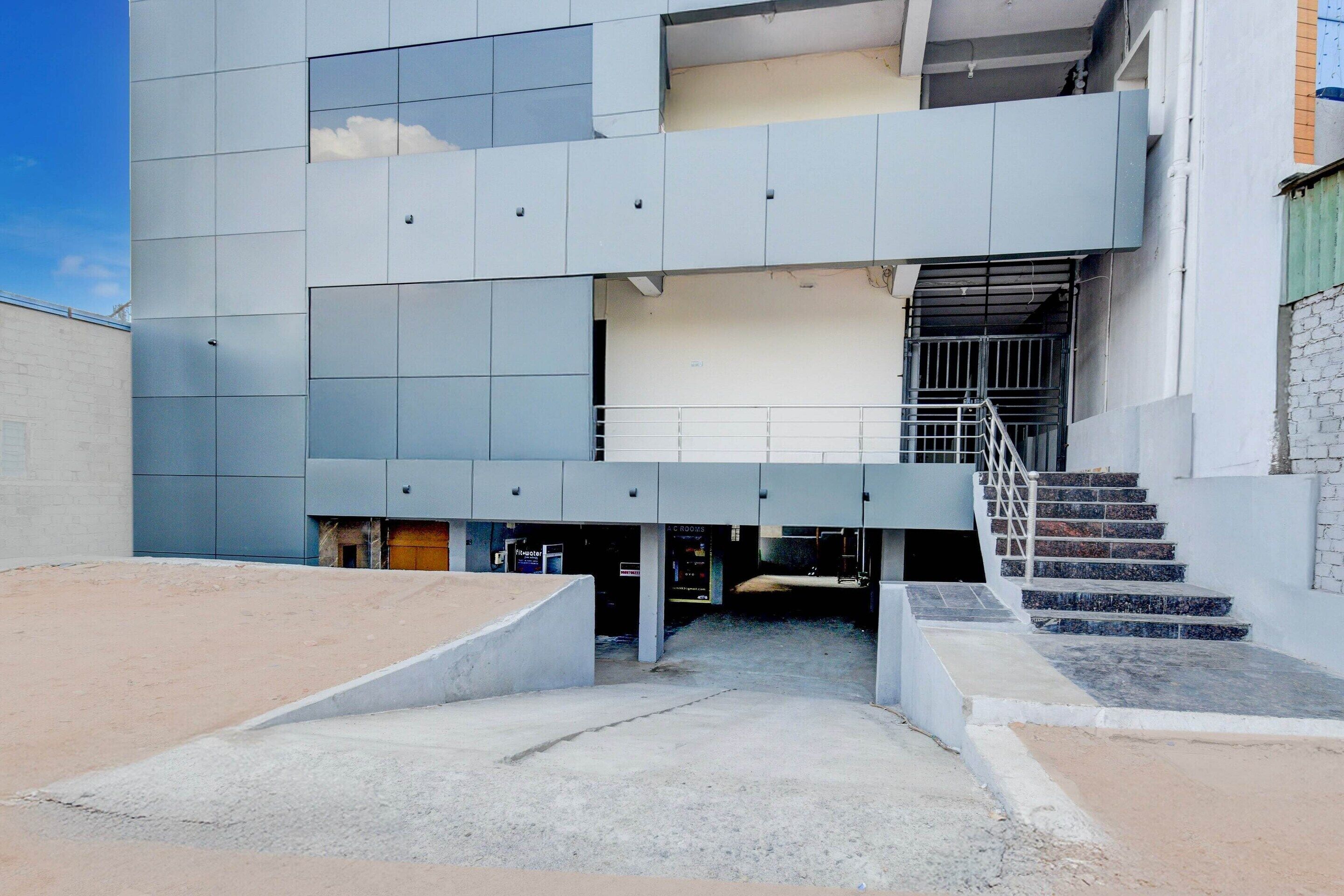 A multi-level building with a staircase, a ramp, and a small outdoor area.