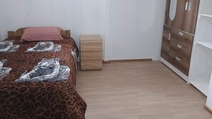 A bedroom with a bed, a nightstand, a wardrobe, and a window. - Tampu Wasi Luci (Distrito de Coya)