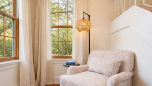 A room with a window, a chair, a floor lamp, and a small table with a book. - Riverfront Escape Near Boston & Transit w/ Parking (Medford)