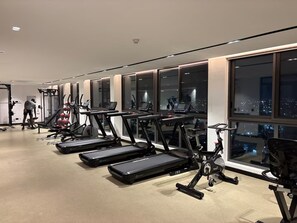 A gym with treadmills, exercise bikes, and weight machines. - Cozy 1-bedroom apartment with AC in pleasant Accra (Accra)