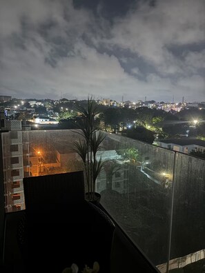 A high-rise building with a glass balcony overlooking a cityscape at night. - Cozy 1-bedroom apartment with AC in pleasant Accra (Accra)
