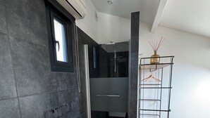 A modern bathroom with a bathtub, a glass shower enclosure, and a wooden floor. - Private cocoon & swimming pool Absolute calm (Rognonas)