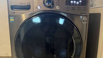 Eine frontbeladene LG Dampfwaschmaschine mit Bedienfeld, Kennzeichnungsetiketten und Garantieaufkleber.