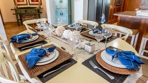 Mesa de jantar posta para seis pessoas, com pratos, talheres e copos.