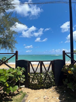 A beach view with a wooden gate, sandy beach, and ocean. - Family Beach Escape | Playa Las Ballenas | Private Pool & Terrace (Las Terrenas)