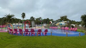 Un parco acquatico con piscina, scivoli e strutture di gioco.