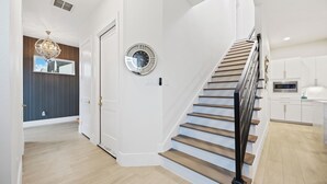 Ein modernes Interieur mit Treppe, einer Uhr und einer Küchenzeile.