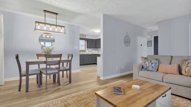 Un salon moderne avec une table à manger, un canapé et une cuisine en arrière-plan.