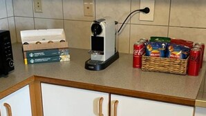 A kitchen with white cabinets, a coffee maker, and a basket of snacks. - Quaint 3-bedroom apartment in charming Ásbrú neighborhood (Ásbrú)