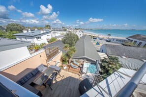 Terraza en la azotea con piscina, asientos y vistas a la playa.