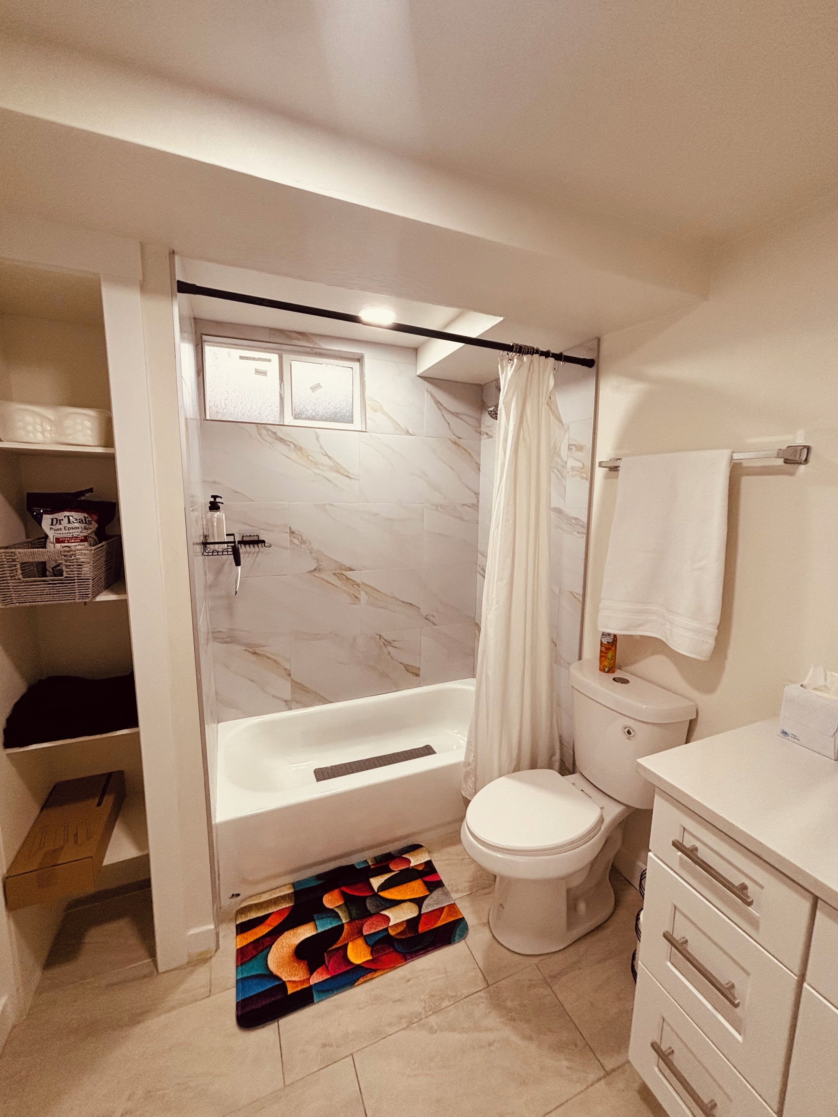 Un baño con bañera, inodoro y cortina de ducha.