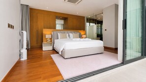 Un dormitorio moderno con una cama grande, mesitas de noche, un espejo y una puerta corrediza de cristal.