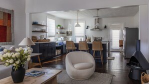 A modern kitchen with a dining area, a fireplace, and a large window. - Near Benning, Steps to Riverwalk/Bibb Mill, 2 Kings, Queen Sofa Bed, Sleeps 6 (Columbus)