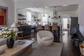 A modern kitchen with a dining area, a fireplace, and a large window.