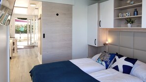 Une chambre moderne dotée d’un grand lit, d’étagères intégrées et d’un espace extérieur visible.