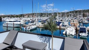 Un port de plaisance avec des bateaux amarrés, un ciel dégagé et une enseigne indiquant « Marina Pearl ».
