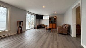 A spacious living area with a large window, a built-in entertainment unit, and a cozy seating area.