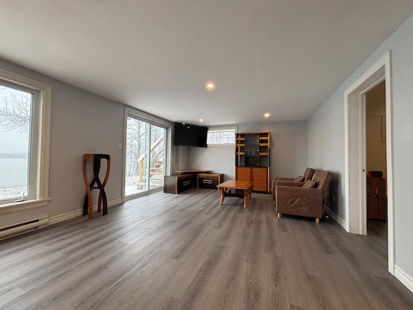 A spacious living area with a large window, a built-in entertainment unit, and a cozy seating area.