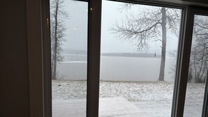 A view through a window with a view of a lake and trees.