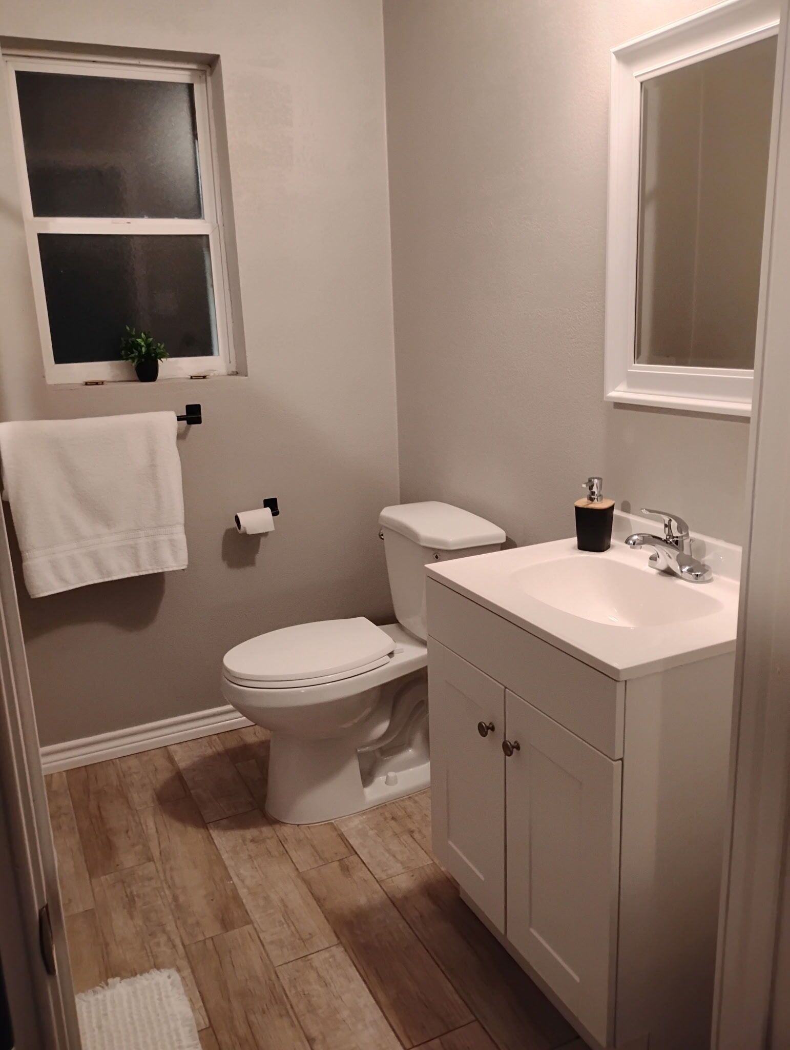 Ein Badezimmer mit Toilette, Waschbecken und Fenster.