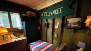 Una habitación con una cama, un escritorio y un cartel que dice 'OCEEDANKEE'.
